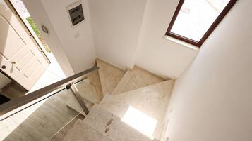 A staircase with a glass railing leading to a landing.