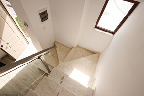 Una escalera con barandilla de cristal que lleva a una plataforma.
