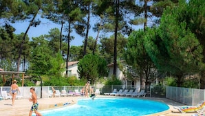 A swimming pool surrounded by trees, with lounge chairs and a fence. - Apartment by Lake Clarens With Pool (Casteljaloux)