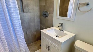 Ein Badezimmer mit Dusche, Waschbecken und Toilette.