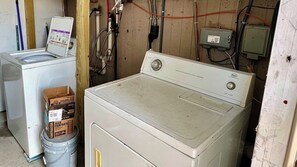 A laundry room with two washing machines, a paint can, and electrical boxes. - SunShell 1 - 4 min walk to Beach (Fort Myers)