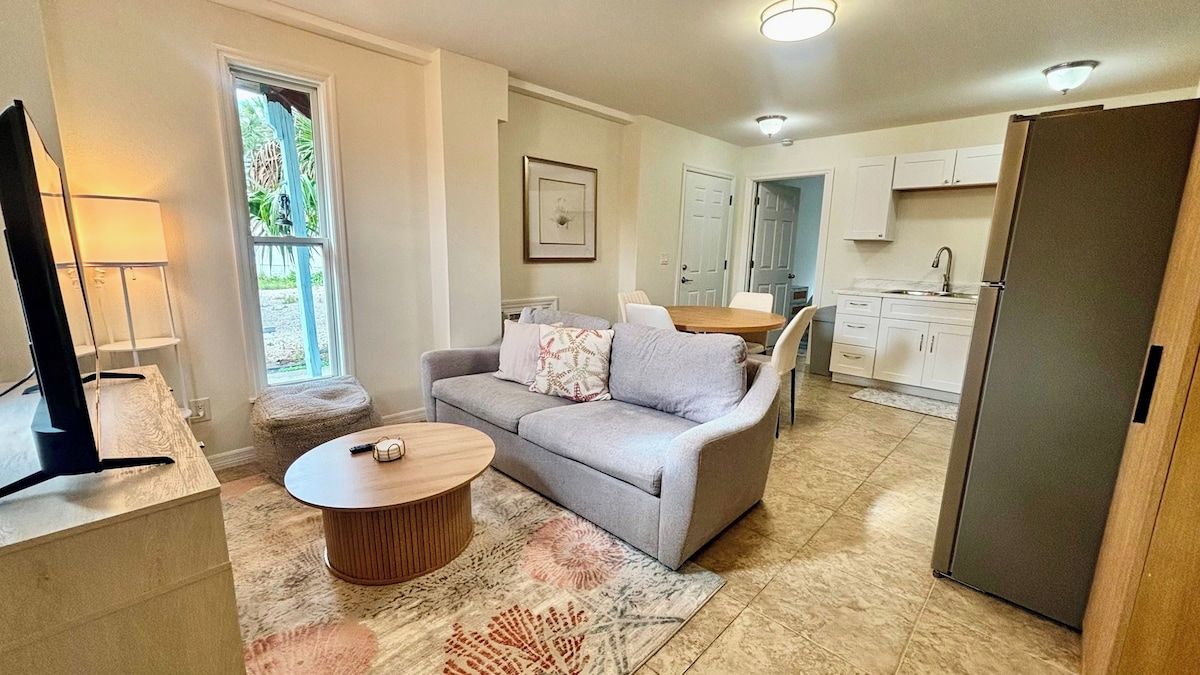 A living room with a sofa, coffee table, and a television.