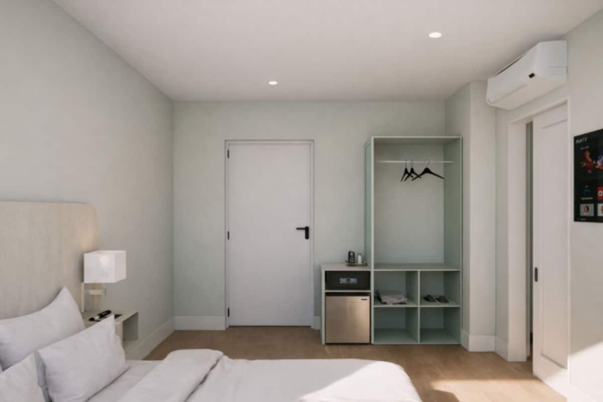 Et moderne soveværelse med seng, natbord, garderobe og indbygget skoskab.