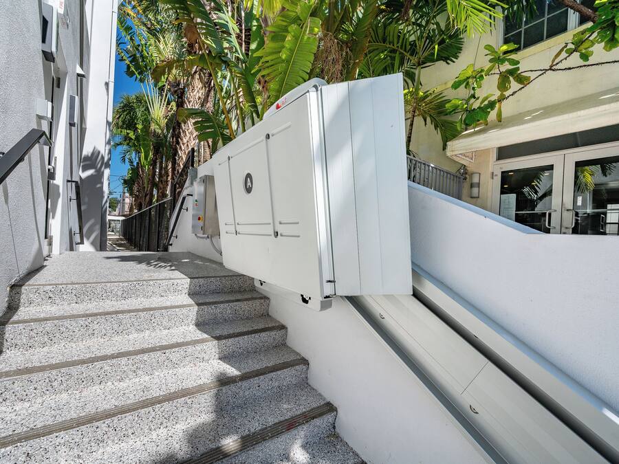 Eine Treppe mit einer weißen Wand und einem weißen Stromverteiler rechts.