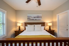A bedroom with a bed, two bedside tables with lamps, a painting on the wall, and a door. - 3BR Retreat Ensuite Baths Fire Pit (Arden)