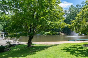 Um parque com um lago, bancos e um coreto.