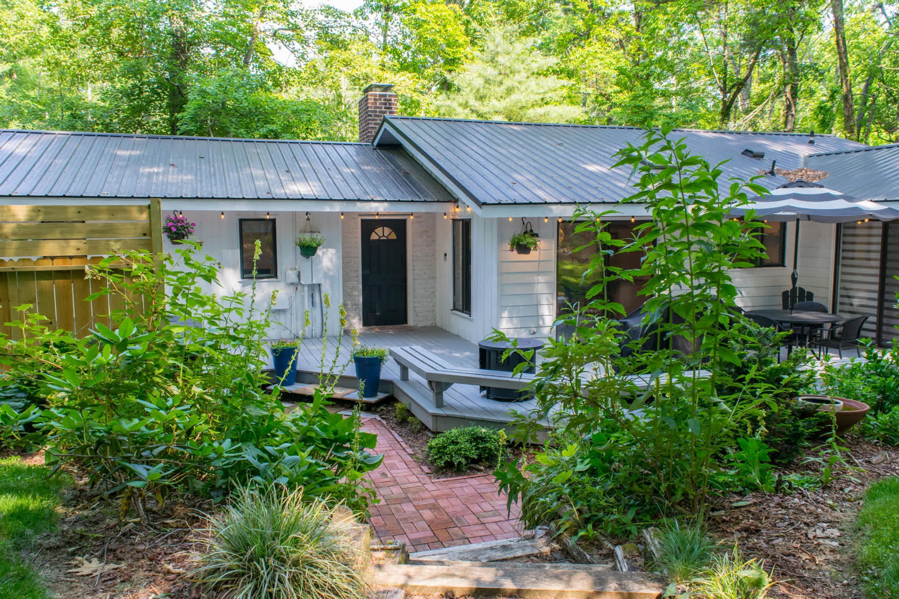 Une maison avec une véranda, un petit jardin et un espace patio.