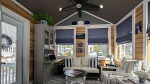 A cozy room with a sofa, a small table, and a cabinet. - 1BR Tiny Home w King Bed Outdoor Space (Flat Rock)