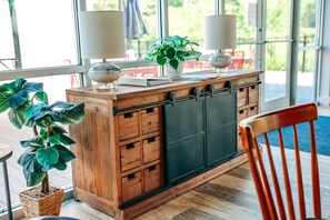 A wooden bar area with a large window, potted plants, and two lamps. - 1BR Tiny Home w King Bed Outdoor Space (Flat Rock)