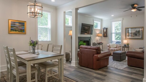 A spacious living room with a fireplace, leather sofas, and a dining area with a table and chairs. - Charming 3BR w Balconies Walk to Flat Rock Playhouse (Flat Rock)