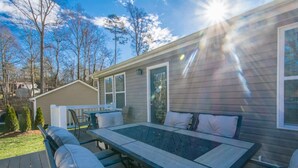 A patio with a table and chairs, a small shed, and a house in the background. - Art-inspired Retreat Free Daily Perks (Asheville)