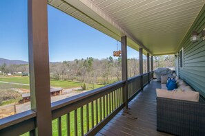 A covered porch with a view of a green landscape and mountains. - Scenic 4BR w Deck Farm Views Near Asheville (Fairview)