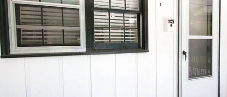 A white building with two windows and a door.
