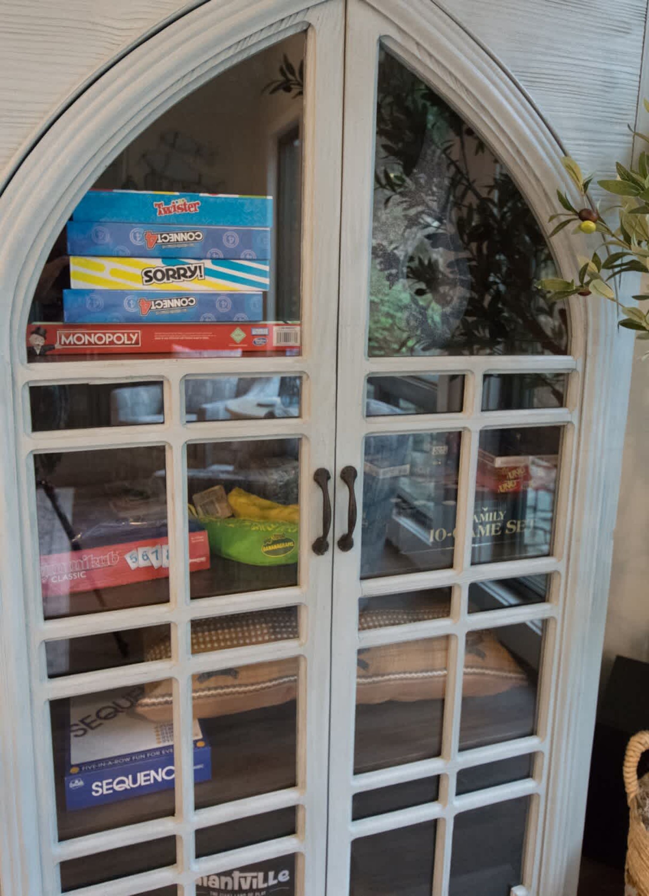 Un meuble avec des portes en verre où sont exposés différents jeux de société.