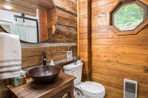 A rustic wooden bathroom with a wooden sink, a white toilet, and a window with a view of greenery. - Epic 1BR Cabin w Outdoor Fireplace 5 Min to Town (Saluda)