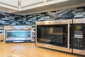 A kitchen with a toaster oven and a microwave. - Charming 2BR Townhouse w Patio Walk to Main St (Hendersonville)