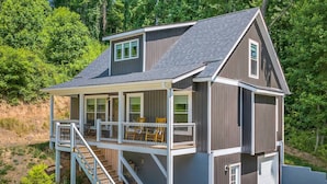 Ein zweistöckiges Haus mit Balkon, Treppe und Garage.