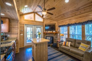 A cozy cabin interior with a kitchen, living area, and fireplace. - Lakeview 2BR Tiny Home Near Trails Pool Bocce (Flat Rock)