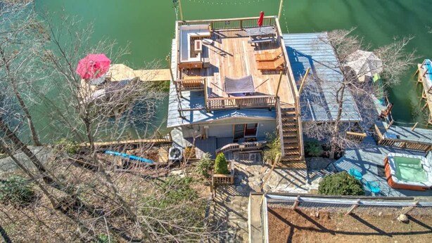 A house with a deck overlooking a body of water, a swimming pool, and a small garden area. - Dog Friendly Tiny House On Lake Lure Private Dock (Lake Lure)