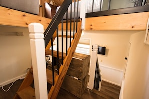A wooden staircase with black railings leading to a lofted bed area. - Dog Friendly Tiny House On Lake Lure Private Dock (Lake Lure)