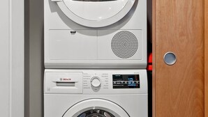 Päältä täytettävä Bosch-pyykinpesukone, jossa on ohjauspaneeli ja pesuaineannostelija yläosassa.