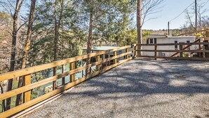 A gravel path leading to a wooden fence and a building with a white exterior. - Lakefront 4BR w Screened Porch (Lake Lure)