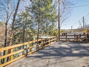 A gravel path leading to a wooden fence and a building with a white exterior. - Lakefront 4BR w Screened Porch (Lake Lure)