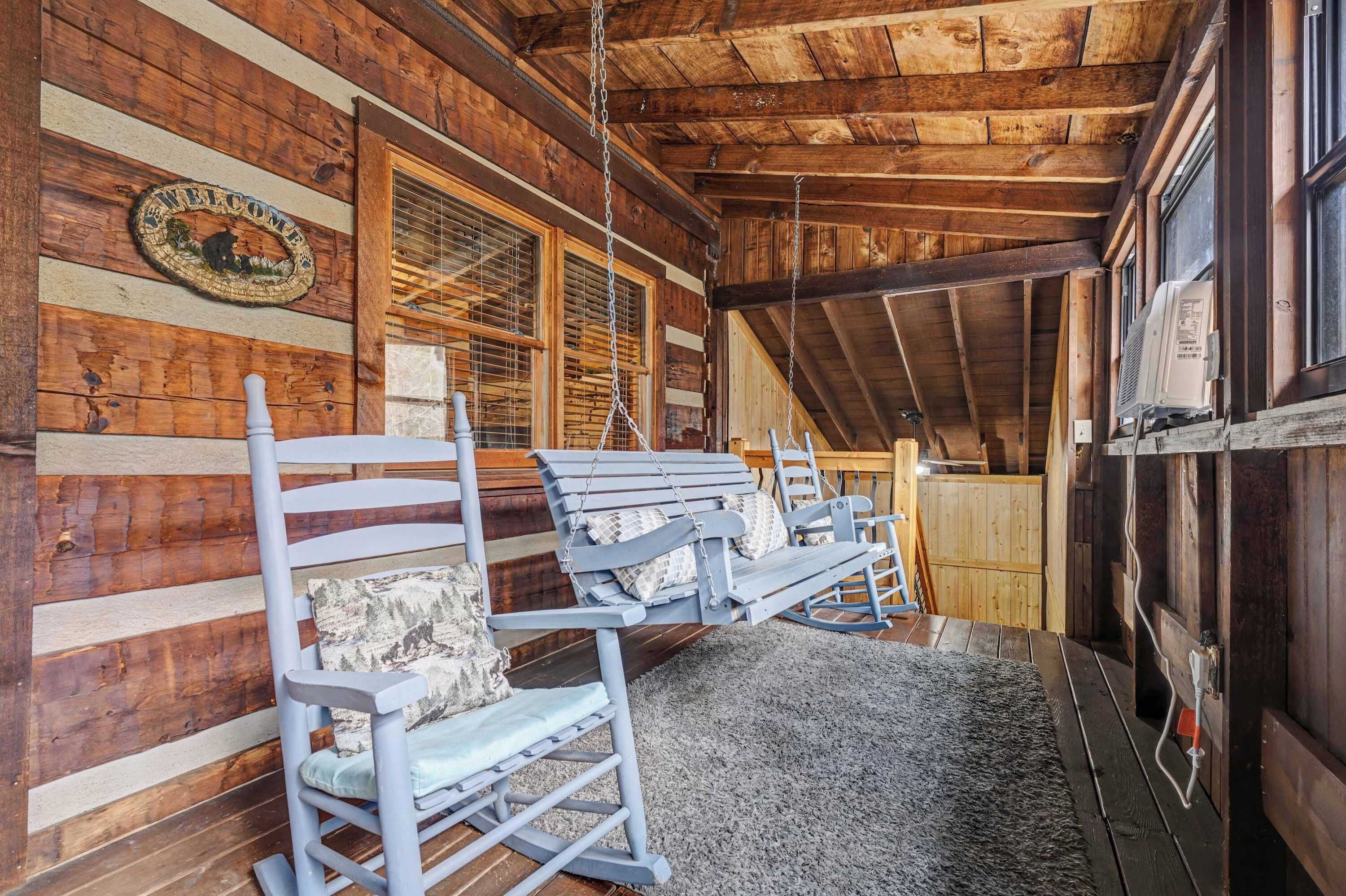 L’intérieur d’une cabane en rondins, avec des murs en bois, un fauteuil à bascule, un banc et une cheminée.