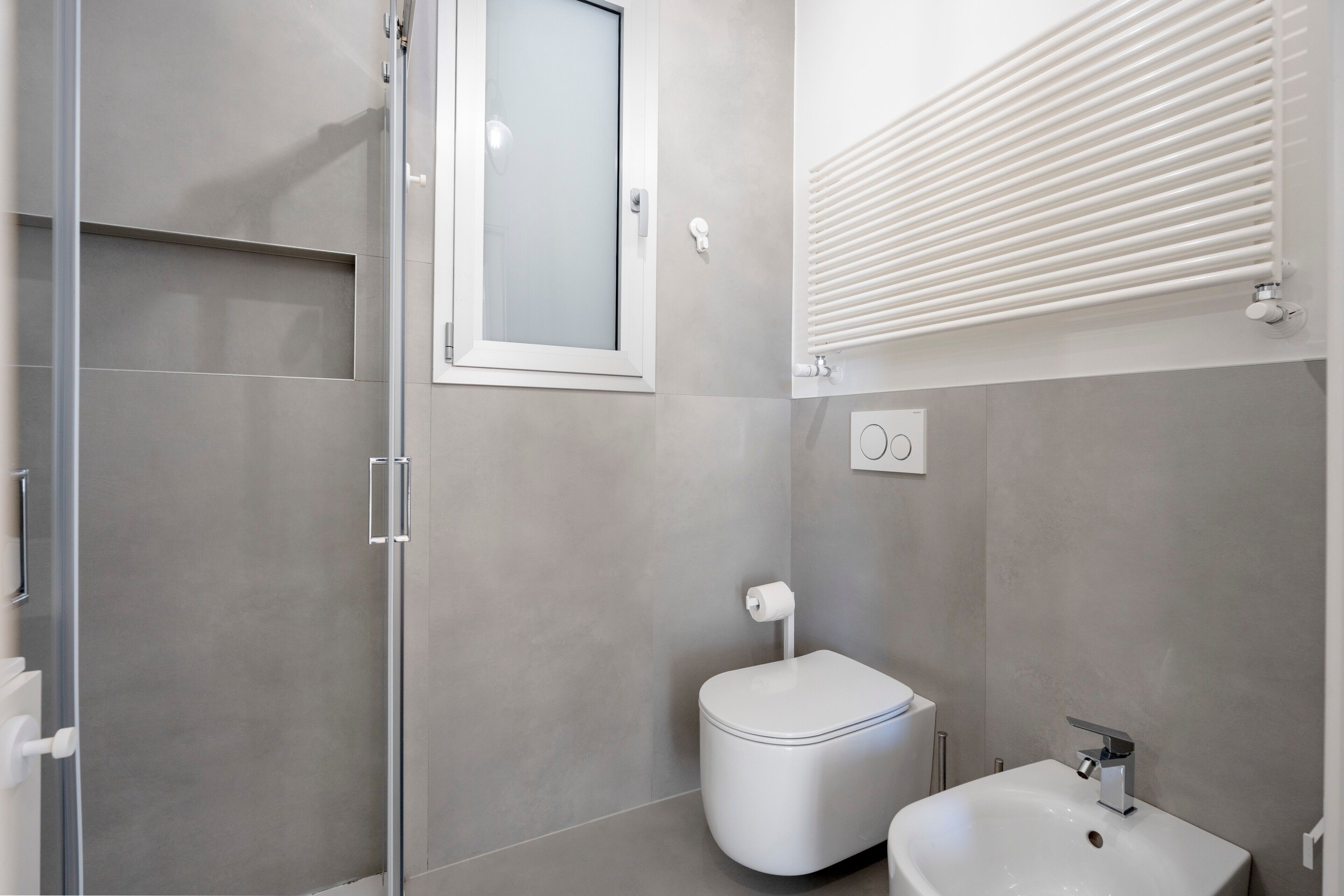 Une salle de bain moderne avec une douche à l’italienne, des toilettes et un lavabo.