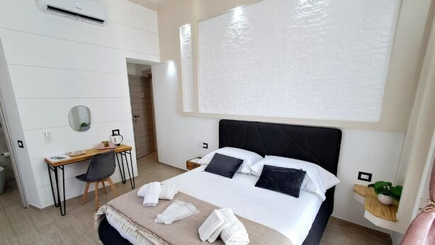 Een moderne hotelkamer met een groot bed, een bureau en een stoel.