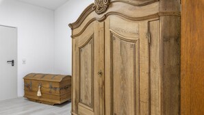 Una habitación con un armario de madera grande, una cómoda y una puerta blanca.