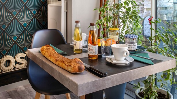Ein Tisch mit Brot, Flaschen, einer Tasse und einem Messer.