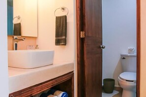 A bathroom with a white sink, a mirror, a towel rack, and a toilet. - Gama 09 Apartments - Studio with a Balcony (TULUM)