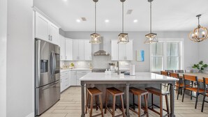 A modern kitchen with a large island, stainless steel appliances, and pendant lighting. - Huge Waterfront Home - Sleeps 20, private pool (gulf shores)