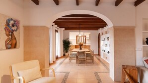 An interior with a sofa, dining table, chairs, a wooden bench, and a wall with shelves. - House "Valldemossa Paradise". (Valldemossa)