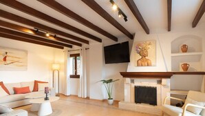 A living room with a fireplace, sofa, coffee table, and a television. - House "Valldemossa Paradise". (Valldemossa)