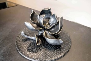 A decorative metal flower sculpture on a textured black plate. - Upstairs apartment in Plymouth by STAE-Homes (Plymouth)