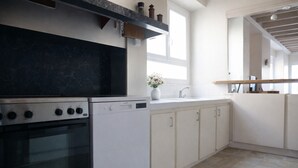 Eine moderne Küche mit schwarzem Arbeitsplatz, weißen Schränken und einem eingebauten Backofen.