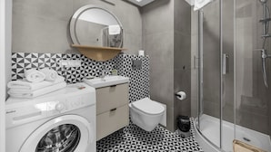 Un bagno funzionale con lavatrice, toilette e doccia.