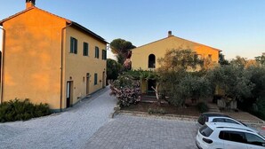 A building with a paved driveway and a parked car. - Triple Room - Podere Cavallone - Space and Nature near Florence (Montelupo Fiorentino)