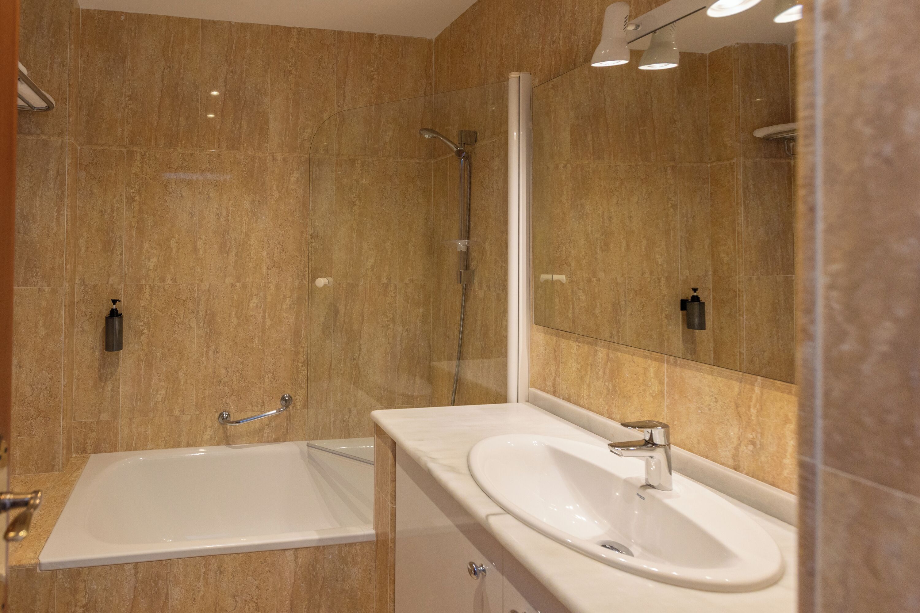 A modern bathroom with a bathtub, a sink, and a shower.