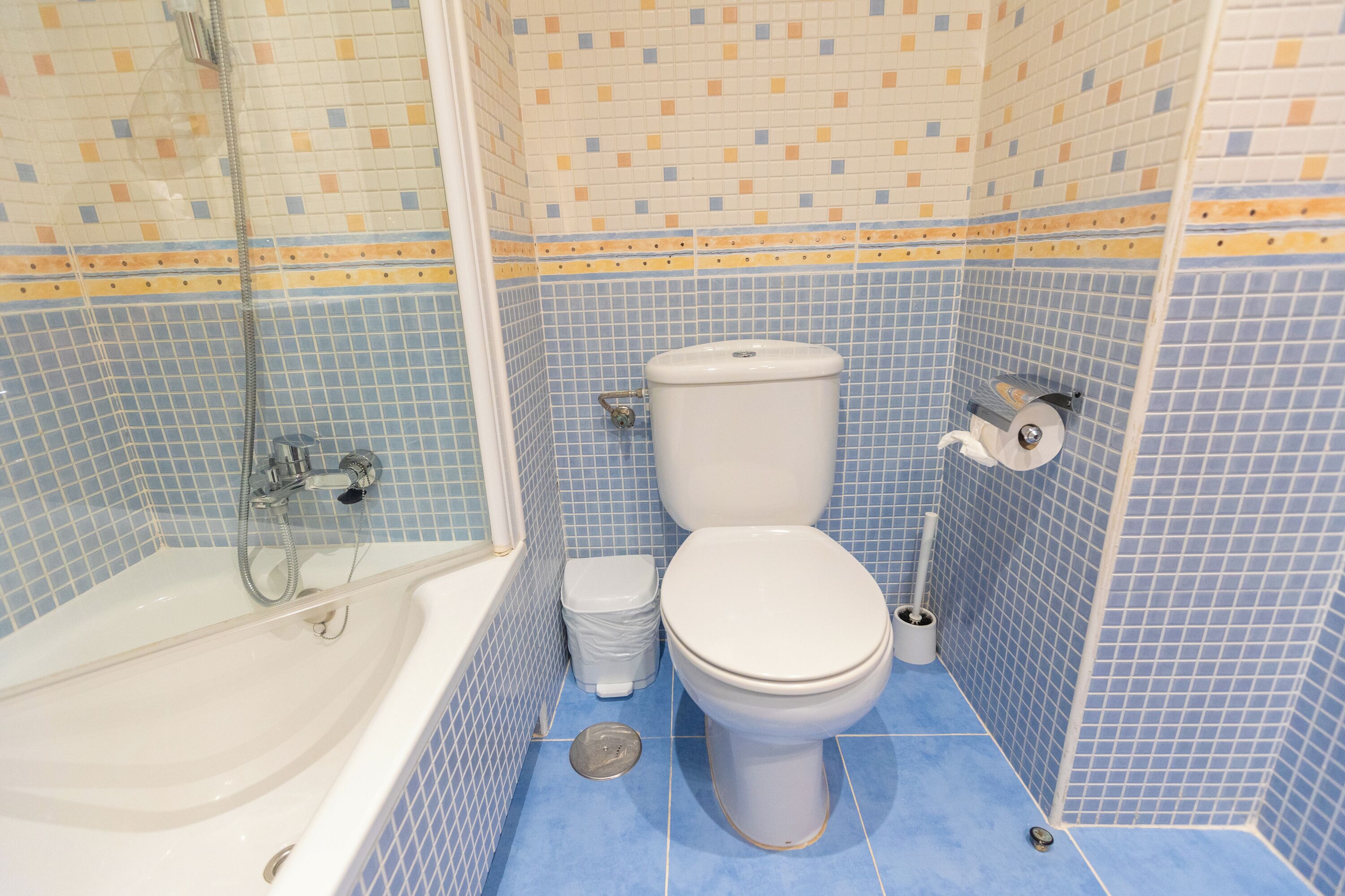 A bathroom with a bathtub, toilet, and shower.