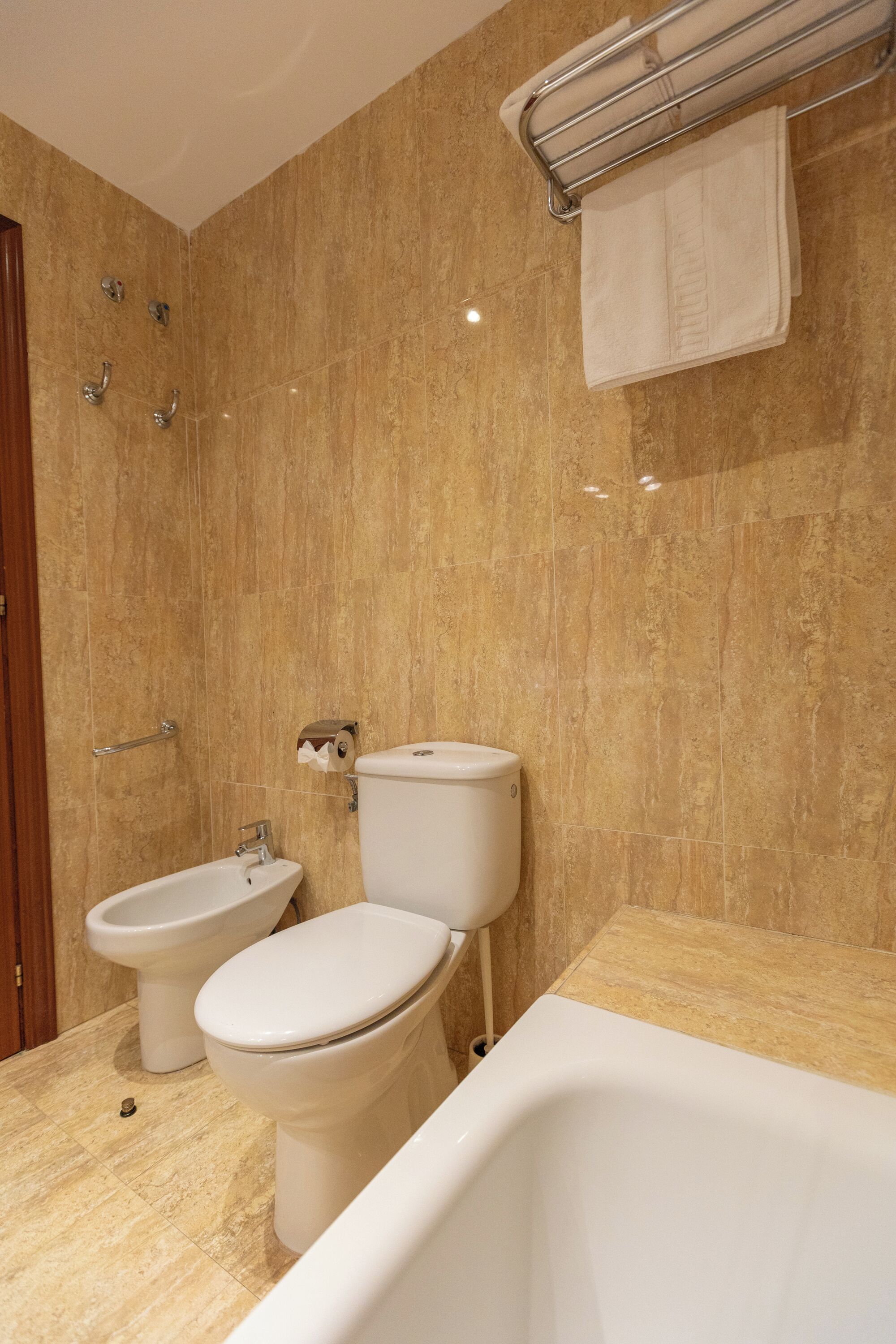 Une salle de bain équipée d’un bidet, de toilettes et d’une baignoire.