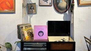 A wall with framed photographs, a vintage radio, and a bicycle. - Hostal Casa de Zeferina (Tuxtla Gutiérrez)