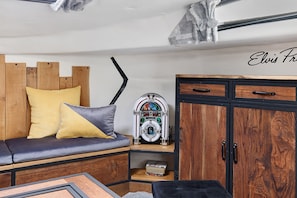 Una habitación con un banco de madera, una radio antigua y un armario.