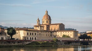 A historic building with a prominent dome and bell tower, situated by a river. - BYPILLOW Del Presto (Florence)