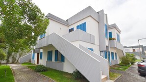Un edificio residencial moderno de varios pisos con una escalera que conduce a la entrada.
