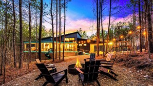 A cabin with a fire pit and outdoor seating, surrounded by trees. - Fall Promo! Luxe & Kid Approved! Playset, EV (Broken Bow)