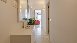 En hall med en vit receptionsdisk, en röd soffa och ett stort fönster längst in.