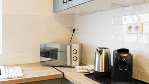 Eine Küche mit Toaster, Kaffeemaschine und Wasserkocher auf der Arbeitsfläche.